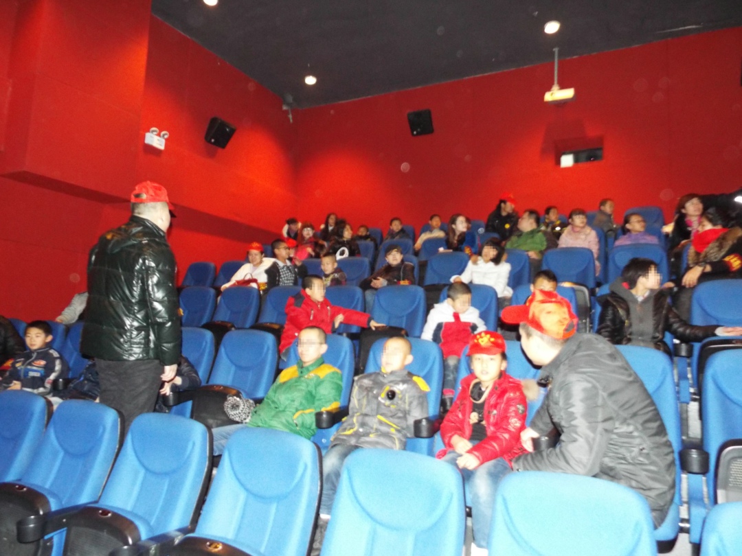 03志愿者安排孩子们坐好，等候电影开演